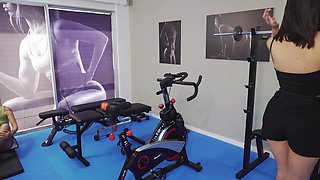 Gym trainer shows to two ladies what a good workout is