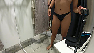 Girl undresses and touches herself in public in the dressing room of a clothing store.