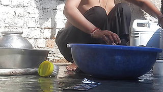 Indian stepsister is preparing to take a bath while washing clothes in the open courtyard of the house