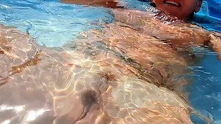 Milf seductress fingering her shaved pussy in the pool