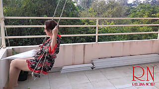 Cute lady is swinging on a hanging swing, hiding from the rain under an umbrella. 185 2
